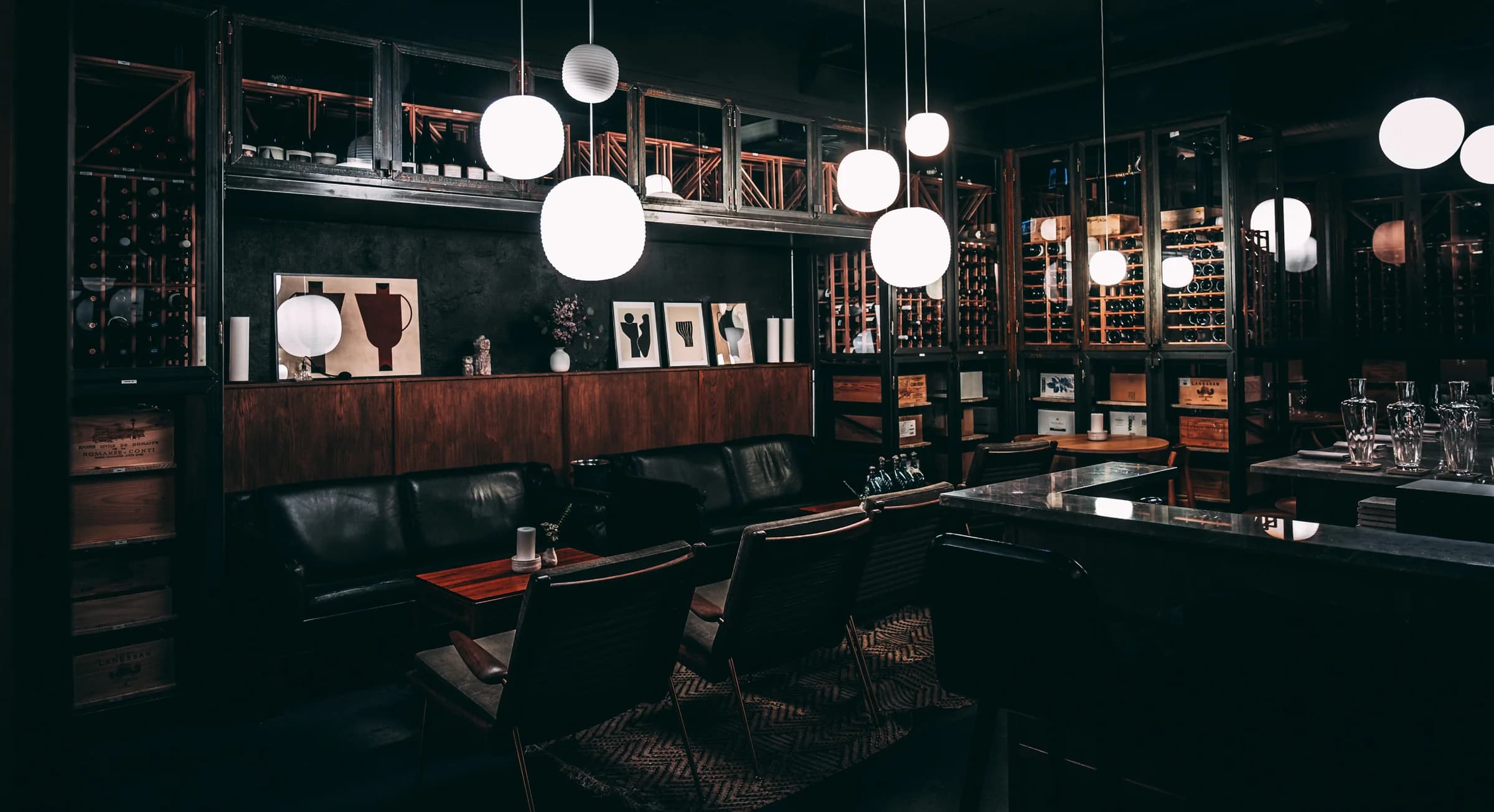The Three Fifty lounge with leather seating, wine cabinets, and globe pendant lights